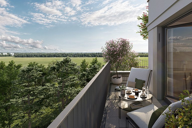 Ein gemütlicher Balkon mit Blick auf eine weite, grüne Landschaft mit Bäumen. Auf dem Balkon steht ein kleiner Tisch mit Frühstücksutensilien, umgeben von bequemen Stühlen. Topfpflanzen sorgen für einen Hauch von Grün.