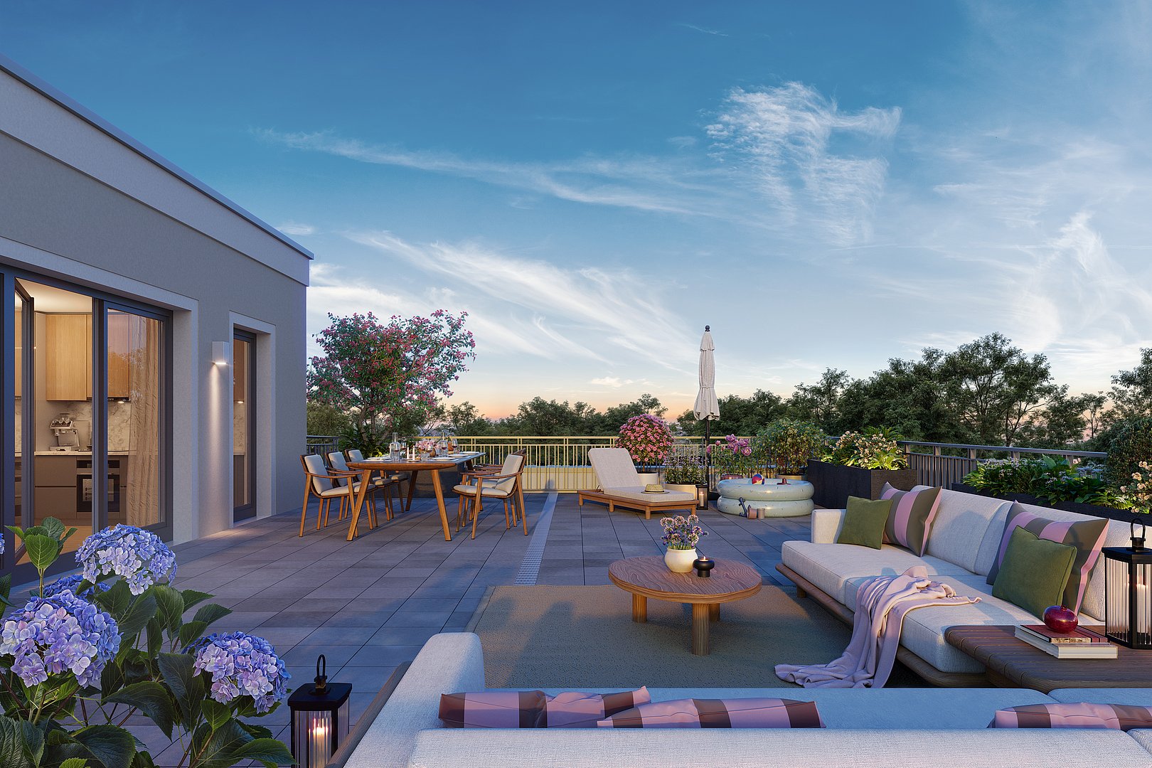 Großzügige Dachterrasse mit Lounge-Bereich, Esstisch, Liege und vielen Pflanzen sowie Blick ins Grüne bei Sonnenuntergang – exklusive und hochwertiger Neubauwohnung in München mit Weitblick ins Grüne.